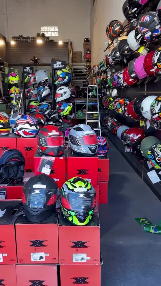 Parede de capacetes e acessórios na loja da Leal Moto Parts